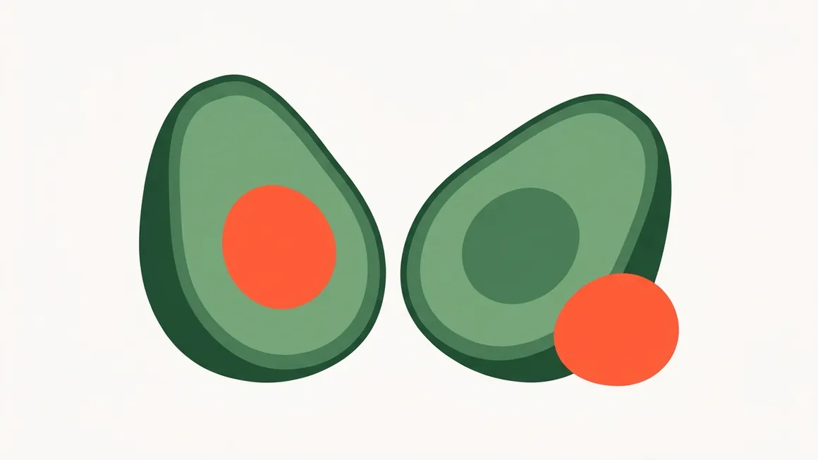 An avocado cut in half, showing the flesh separated from the pit.